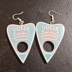 Unlock The Mysteries Of The Universe With These Mesmerizing Ouija Planchette Earrings. Handmade Resin Planchette Design Light Pink And Light Blue Hues With Shimmering Silver Glitter Lightweight French Hook Style For All-Day Comfort These Enchanting Earrings Tap Into The Energy Of The Ouija Board, Allowing You To Connect With The Spiritual Realm. The Ethereal Pastel Colors And Glittering Accents Create An Otherworldly Look That's Sure To Turn Heads. Whether You're A Crystal-Loving Mystic Or Just Emo Earrings, Goth Earrings, Cute Emo, Ouija Board, Emo Goth, Quirky Gifts, West London, Organza Gift Bags, Black Glitter