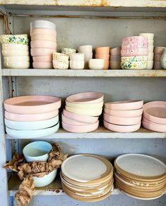 many plates and bowls are stacked on shelves