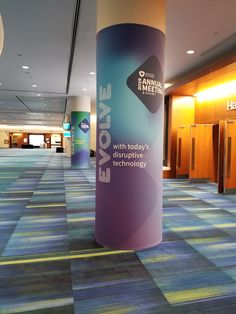 an empty room with colorful carpeting and large roll - up banner in the center