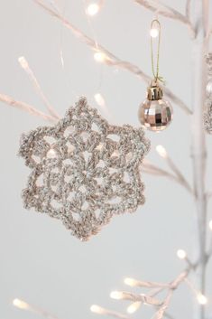 a silver ornament hanging from a christmas tree