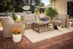 a woman sitting on top of a couch next to a dog laying on the ground