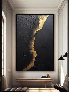 a large black and gold painting hanging on the wall above a bench in a living room