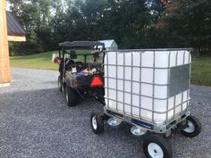 a golf cart with a cooler attached to the back is parked next to another vehicle