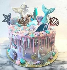 there is a cake decorated with mermaid decorations