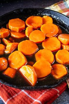 cooked carrots are in a skillet on a table