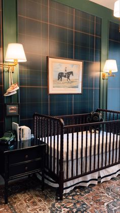 a baby's room with a crib, lamp and pictures on the wall