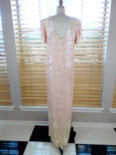 "This is an absolutely gorgeous gown. It's very intricately embellished with pink pearl beading and iridescent pink sequins. It's in good vintage condition. Size SMALL Measurements: Bust - 34/36\" Waist - 34/36\" Hips - 34/36\" Length - 57\" Size - Small Size LARGE Measurements: Bust - 42/44\" Waist - 42/44\" Hips - 42/44\" Length - 59\" Size - Large This dress comes from a pet-free and smoke-free home. If you would like more info or have any questions, please don't hesitate to ask!" Pink Sequin Formal Dress, Glamorous Pink Embellished Mother Of The Bride Dress, Pink Floor-length Sequin Dress For Prom Season, Pink Floor-length Sequin Dress For Prom, Pink Sequin Dress With Fitted Bodice For Wedding, Pink Sequin Wedding Dress With Fitted Bodice, Elegant Pink Sequin Dress For Wedding, Pink Sequined Evening Dress With Fitted Bodice, Formal Pink Sequined Mother Of The Bride Dress