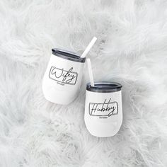 two white tumblers sitting on top of a fluffy white fur covered floor next to each other