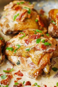 some chicken wings covered in sauce and green onions