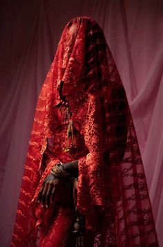 a woman dressed in red sitting on a chair