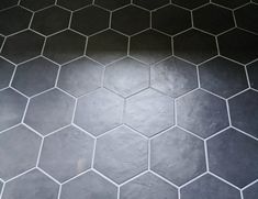 a black and white tiled floor with hexagonal tiles on it's sides