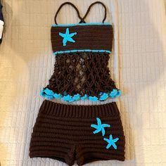 a crocheted swimsuit and diaper cover are laying on top of a bed