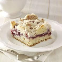 a piece of cake sitting on top of a white plate next to a fork and cup