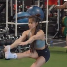 a woman is squatting down with her leg in the air while holding a tennis racquet