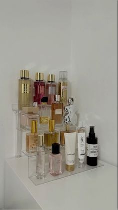 a shelf filled with lots of different types of perfumes on top of each other