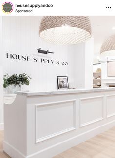 the front desk of a house supply co store with white walls and wood flooring