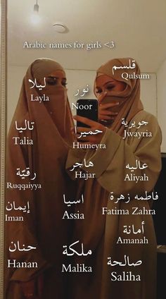 two women wearing headscarves are standing in front of a mirror with names written on it