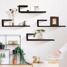 a person standing in front of shelves with plants on them