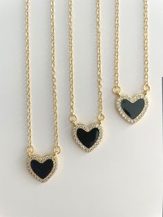 Our dainty black heart trendy necklace is the perfect addition to any outfit. The delicate black heart charm is made from high-quality materials and hangs on a fine chain. The black heart adds a modern and edgy touch to the classic heart shape, making it a must-have for any fashion-forward jewelry collection. The necklace is versatile and can be worn with both casual and formal attire, making it ideal for any occasion. Its minimalistic design makes it perfect for layering with other necklaces to Black Heart Necklace, Black Hearts, Trendy Necklace, Hearts Necklace, Trendy Necklaces, Minimalistic Design, Formal Attire, Black Heart, Heart Shape