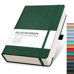 a green notebook sitting next to a stack of colored papers