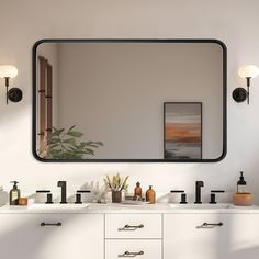 a bathroom vanity with two sinks and a large mirror above it, in front of a white wall