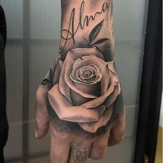 a woman's hand with a rose tattooed on it and the word ann written in cursive writing