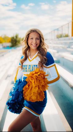 a cheerleader is posing on the bleachers with her pom poms