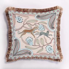 a decorative pillow with an animal design on the front and fringe trimming around it