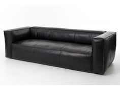 a black leather couch sitting on top of a white floor