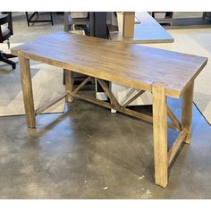 a wooden table sitting on top of a hard wood floor next to a computer desk