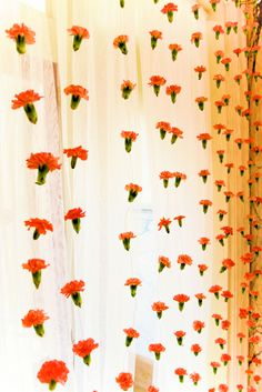 red flowers are attached to the sheer curtains