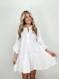 Indulge in luxury with our Collared Button Up Mini Dress. With its collared neckline, button closures, and ruched sleeves, this dress provides an elevated and trendy look. The mini and tiered design is perfect for any occasion, from brunch dates to elegant dinners. Its bright and versatile style is a must-have for your wardrobe, whether for a bridal event or a basic yet sophisticated look. Self 60% Cotton 40% Polyester Hand wash cold. Spring Tiered Button Dress, Spring Tiered Dresses With Buttons, Elegant Tiered Dress With Gathered Sleeves, Elegant Mini-length Tiered Dress With Ruffle Hem, Chic Long Sleeve Tiered Daywear Dress, Chic Long Sleeve Tiered Dress For Daywear, Spring Mini Shirt Dress With Ruffle Hem, Spring Mini Length Shirt Dress With Ruffle Hem, Button-up Ruffle Hem Dress For Daywear