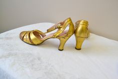 "1930s metallic gold leather t-strap heels. Marked a size 6.5 AA - but they measure 9 5/8\" long inside from toe to heel and 2 5/8\" wide inside, which would make them closer to a 8 or 8.5. The heels are 3.5\" tall. They were sold at Harrison Bros. at The Oranges in Montclair, NJ. In good condition, with just some wear to the metallic finish on the toes, and some wear to the soles. ---> If you need an order shipped by a particular date or shipped via a quicker method, please ask PRIOR to purc Gold T-strap Heels For Formal Occasions, Vintage Gold Heels For Formal Occasions, Classic Gold Leather Heels, Vintage Gold Heels With Almond Toe, Vintage Gold Ankle Strap Heels, Vintage T-strap Heels For Evening, Retro Gold Open Toe Heels, Vintage Gold Closed Toe Heels, Vintage Gold Almond Toe Heels