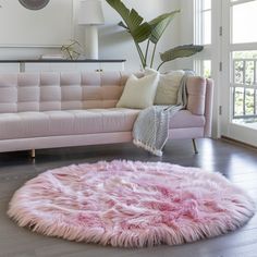 a living room with a pink couch and rug