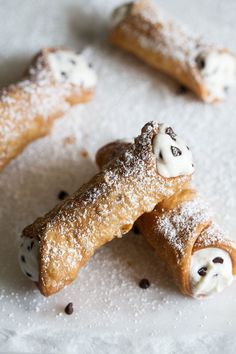 three pastries with white frosting and chocolate chips on them are arranged in the shape of dogs