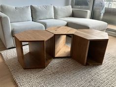 a wooden table sitting on top of a rug in front of a white sectional couch