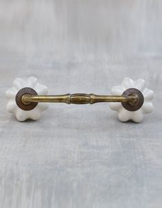 an antique brass and white flower shaped handle