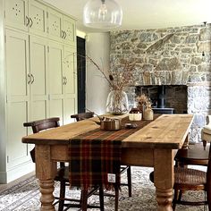 a dining room table with chairs around it and a fireplace in the backround