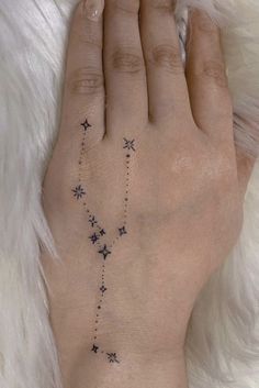 a woman's hand with a star tattoo on it