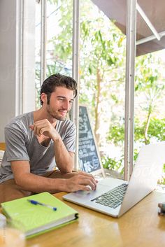 a man sitting at a table using a laptop computer