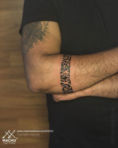 a man's arm with a tattoo on it, in front of a wooden wall