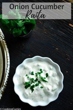 a bowl of onion cucumber kafta next to a plate with cilantro on it