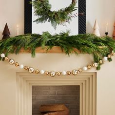 a fireplace decorated with christmas decorations and greenery