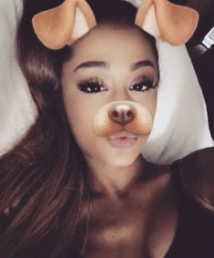 a woman laying on top of a bed with stuffed animals in her ears and nose