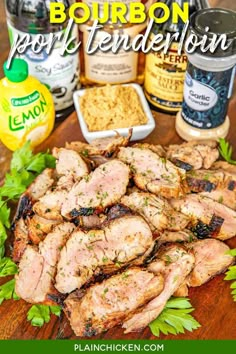 grilled pork tenderies on a cutting board with herbs and seasonings