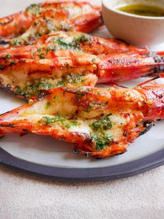 grilled lobsters on a plate with dipping sauce