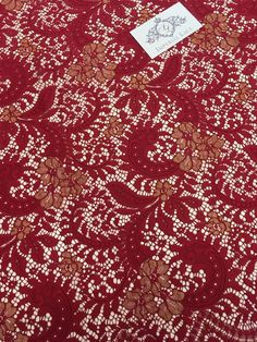 a red table cloth with white and brown designs on it