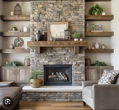 a living room filled with furniture and a fire place in front of a stone fireplace