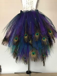 peacock feathers are arranged on top of a mannequin