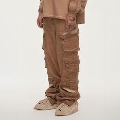 The Distressed Multi-Pocket Layered Cargo Pants in Earth perfectly merge street style with practicality. These cargo pants feature multiple flap pockets on both sides, providing ample storage and a rugged look. The elasticized cuffs create a natural stacking effect when worn, while zippers on the cuffs allow for an adjustable fit around the calves, enhancing mobility. The washed, distressed finish adds a unique edge to the design. Made from premium 100% cotton fabric, these slightly oversized pa Techwear Wide Leg Cargo Pants With Multiple Pockets, Techwear Streetwear Pants With Patch Pockets, Urban Style Cargo Pants With Cargo Pockets, Wide Leg Techwear Cargo Pants With Multiple Pockets, Urban Cargo Pants With Cargo Pockets, Techwear Cargo Pants With Straight Leg, Urban Straight Leg Parachute Pants With Multiple Pockets, Full-length Techwear Cargo Jeans With Hip Pockets, Utility Streetwear Pants With Pockets